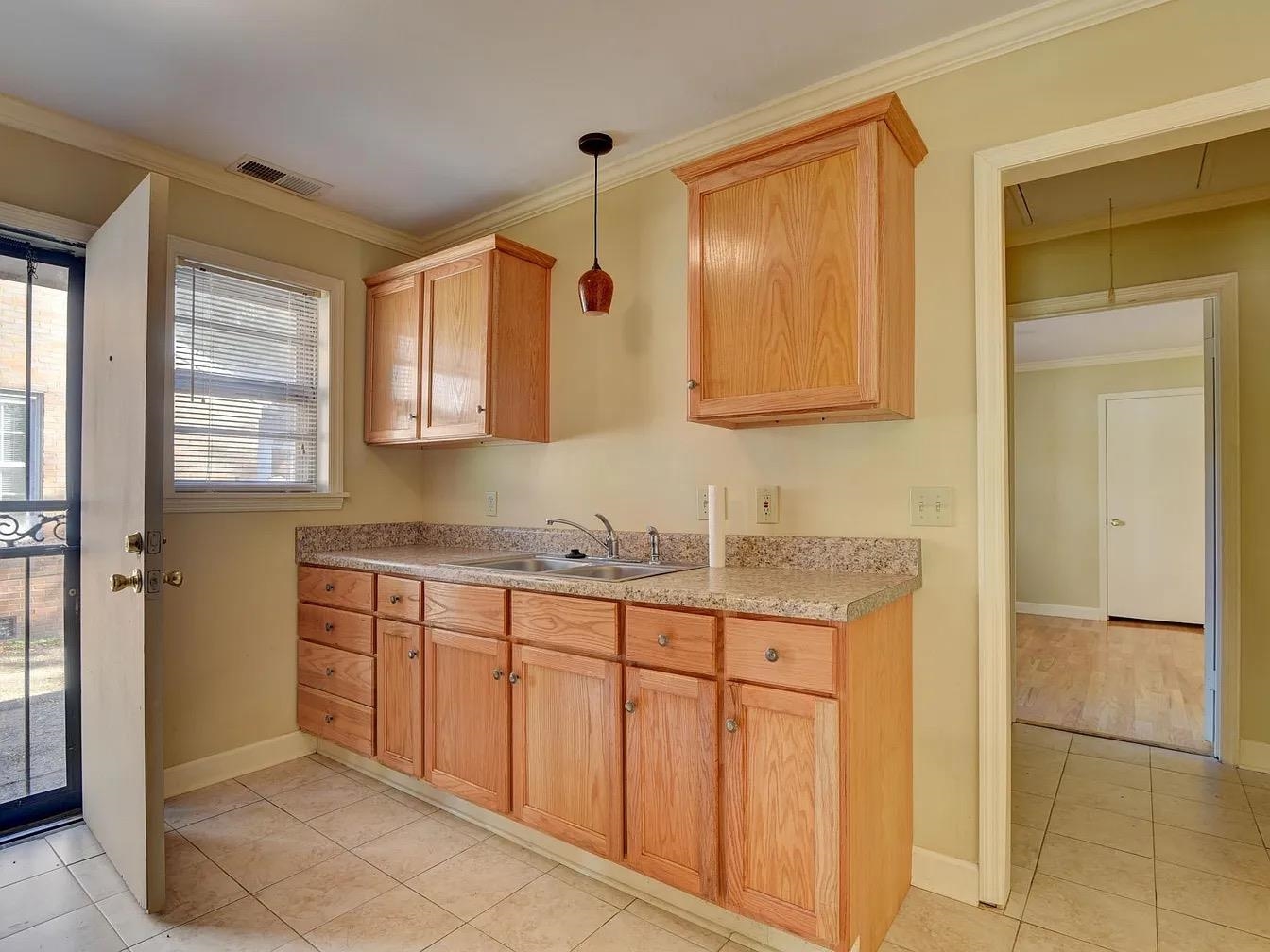370 South Fenwick Road Memphis, TN 38111 - Photo 8 of 13 Kitchen with crown molding, pendant lighting, light countertops, and light tile patterned floors