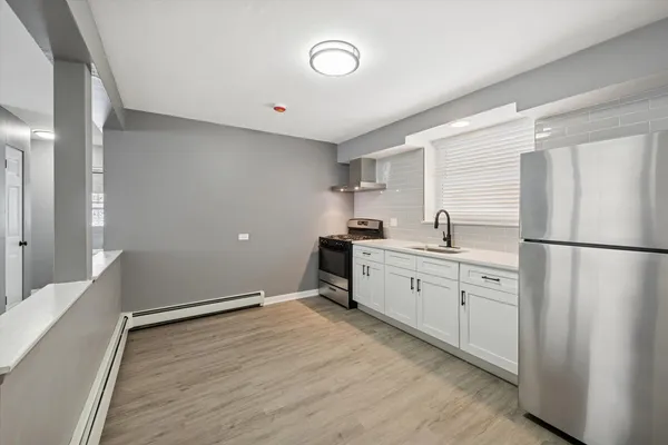 a kitchen with a refrigerator and white cabinets