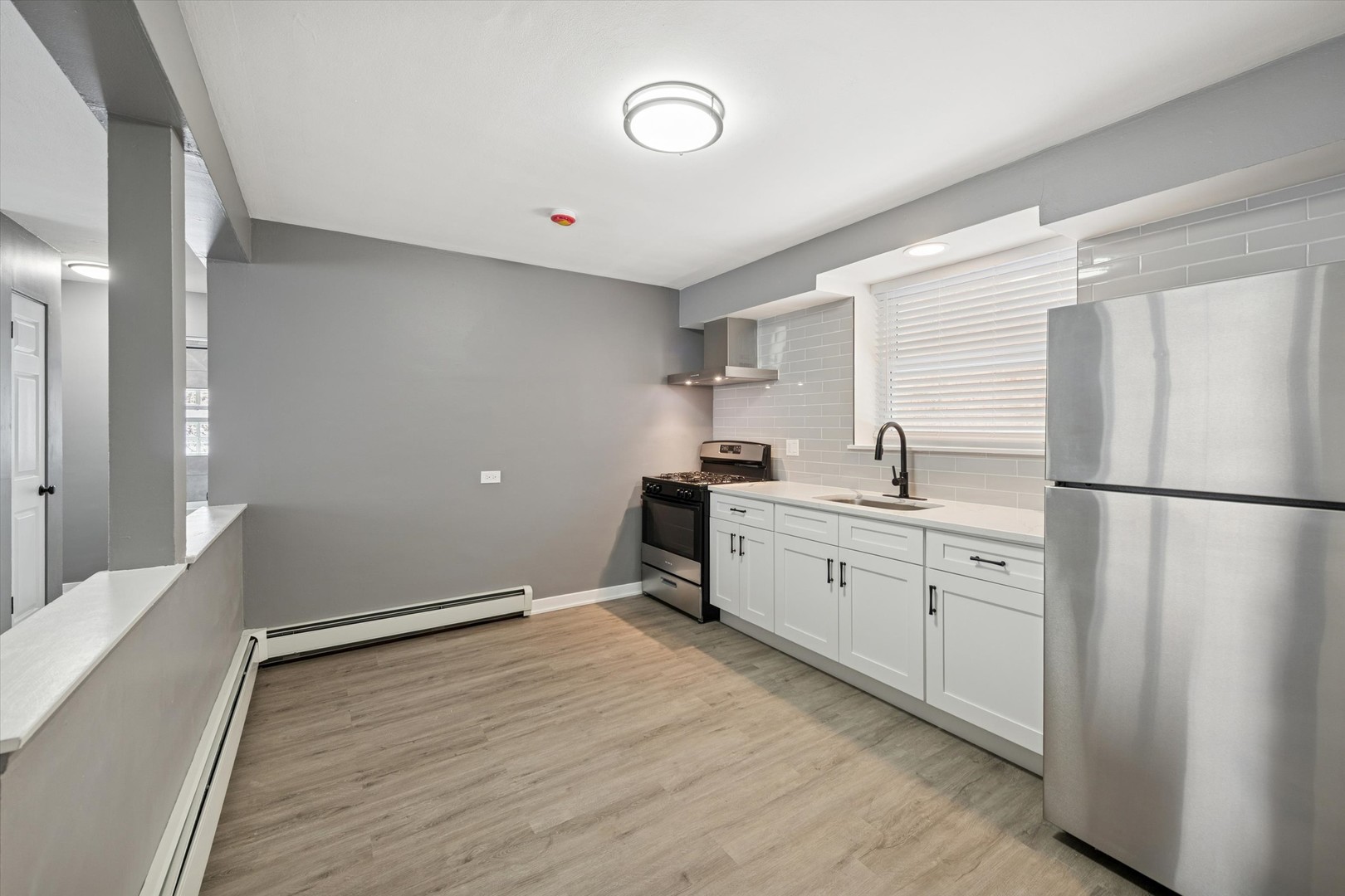 1910 16th Avenue, Unit 3 Broadview, IL 60155 - Photo 2 of 14 a kitchen with a refrigerator and white cabinets