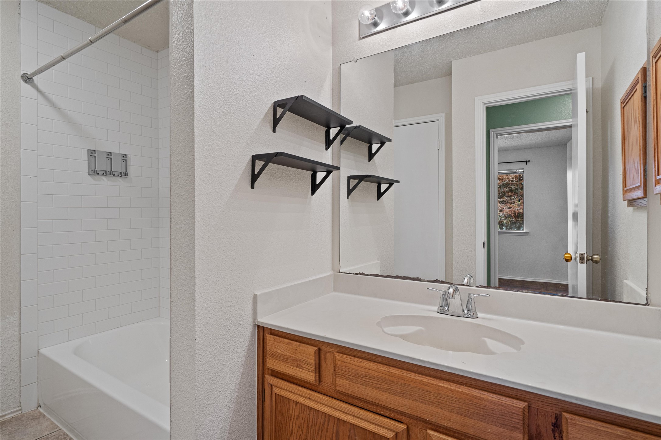 4700 Fallenash Drive Austin, TX 78725 - Photo 27 of 33 a bathroom with a granite countertop sink and a mirror