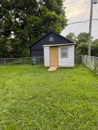 a front view of house with yard and trees all around