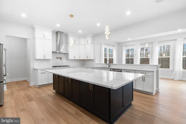 a large kitchen with stainless steel appliances lots of counter space and wooden floor