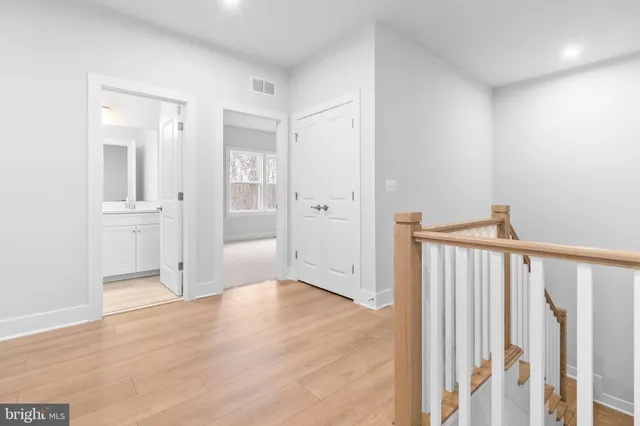 a view of a hallway with wooden floor and entryway