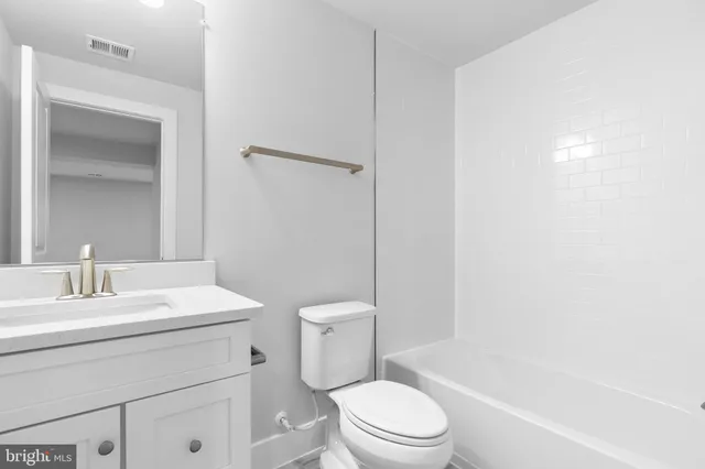 a bathroom with a toilet a sink a mirror and vanity