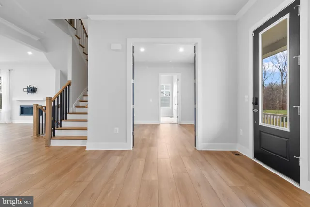 a view of a hallway with wooden floor and stairs