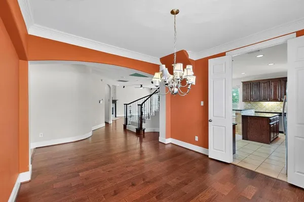a view of a room with wooden floor and a ceiling fan