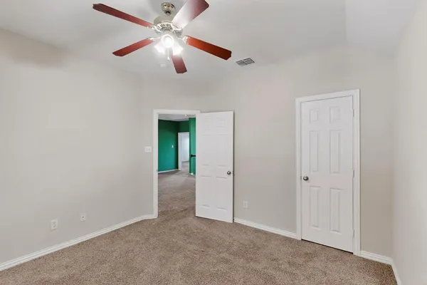 an empty room with closet and fan