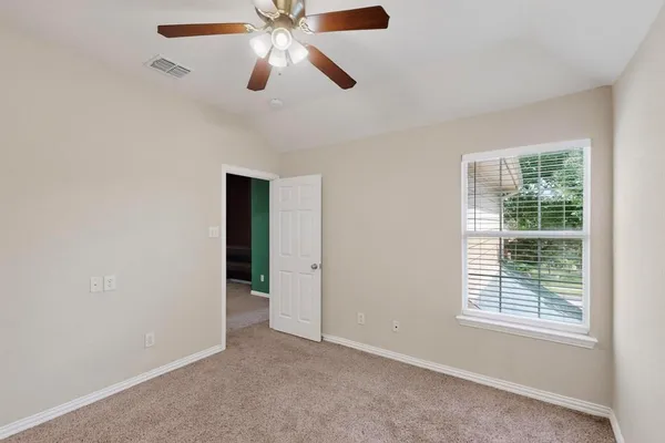 an empty room with fan and windows