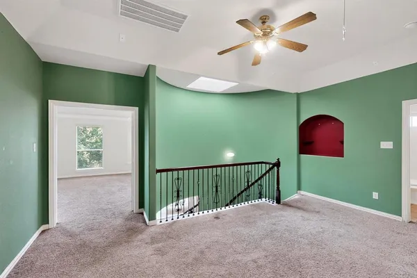 a view of a livingroom with a fan a ceiling fan and a window