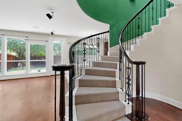 a view of staircase with wooden floor and a large window