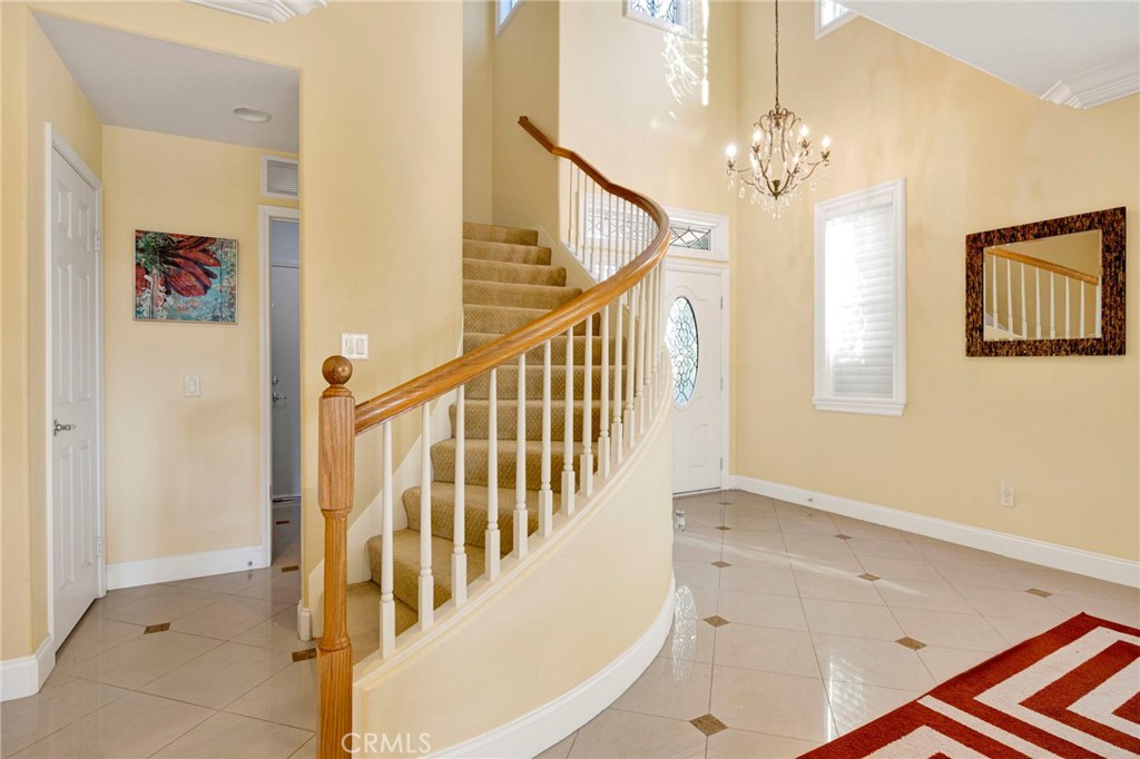 11233 Ravenna Lane Porter Ranch, CA 91326 - Photo 18 of 46 a view of staircase with railing and a chandelier