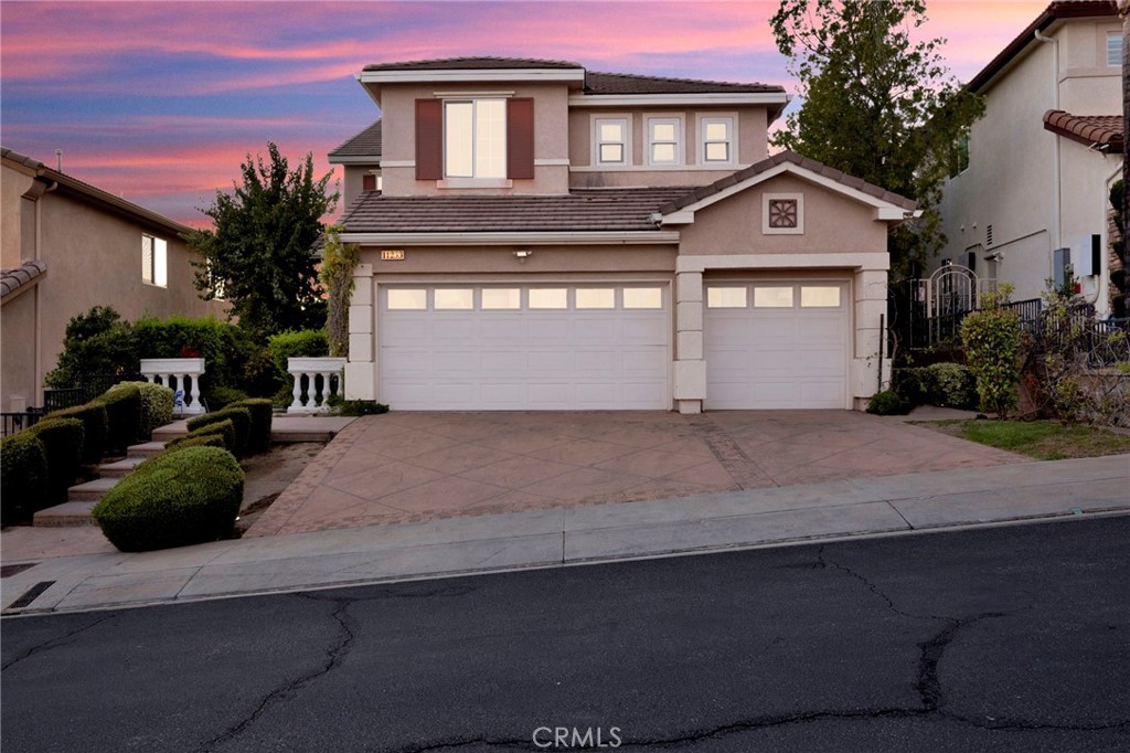 11233 Ravenna Lane Porter Ranch, CA 91326 - Photo 41 of 46 a front view of a house with a yard and garage