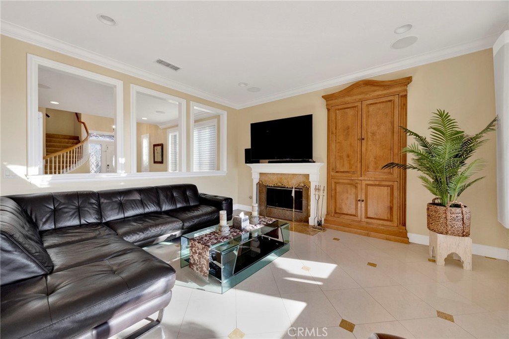 11233 Ravenna Lane Porter Ranch, CA 91326 - Photo 10 of 46 a living room with furniture a fireplace and a flat screen tv