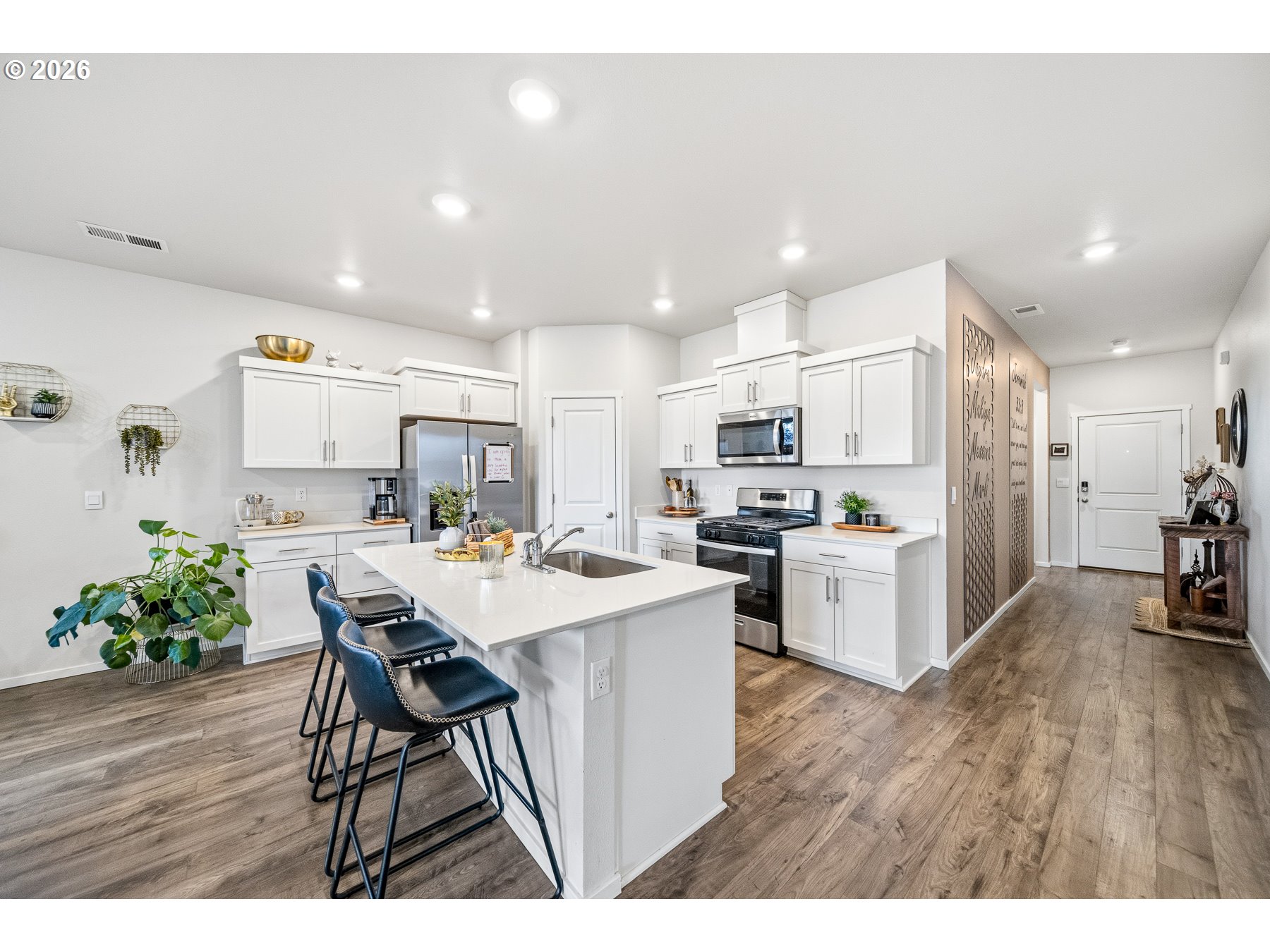 597 Northeast Union Loop Prineville, OR 97754 - Photo 5 of 22 a kitchen with a sink a stove a refrigerator and white cabinets with wooden floor