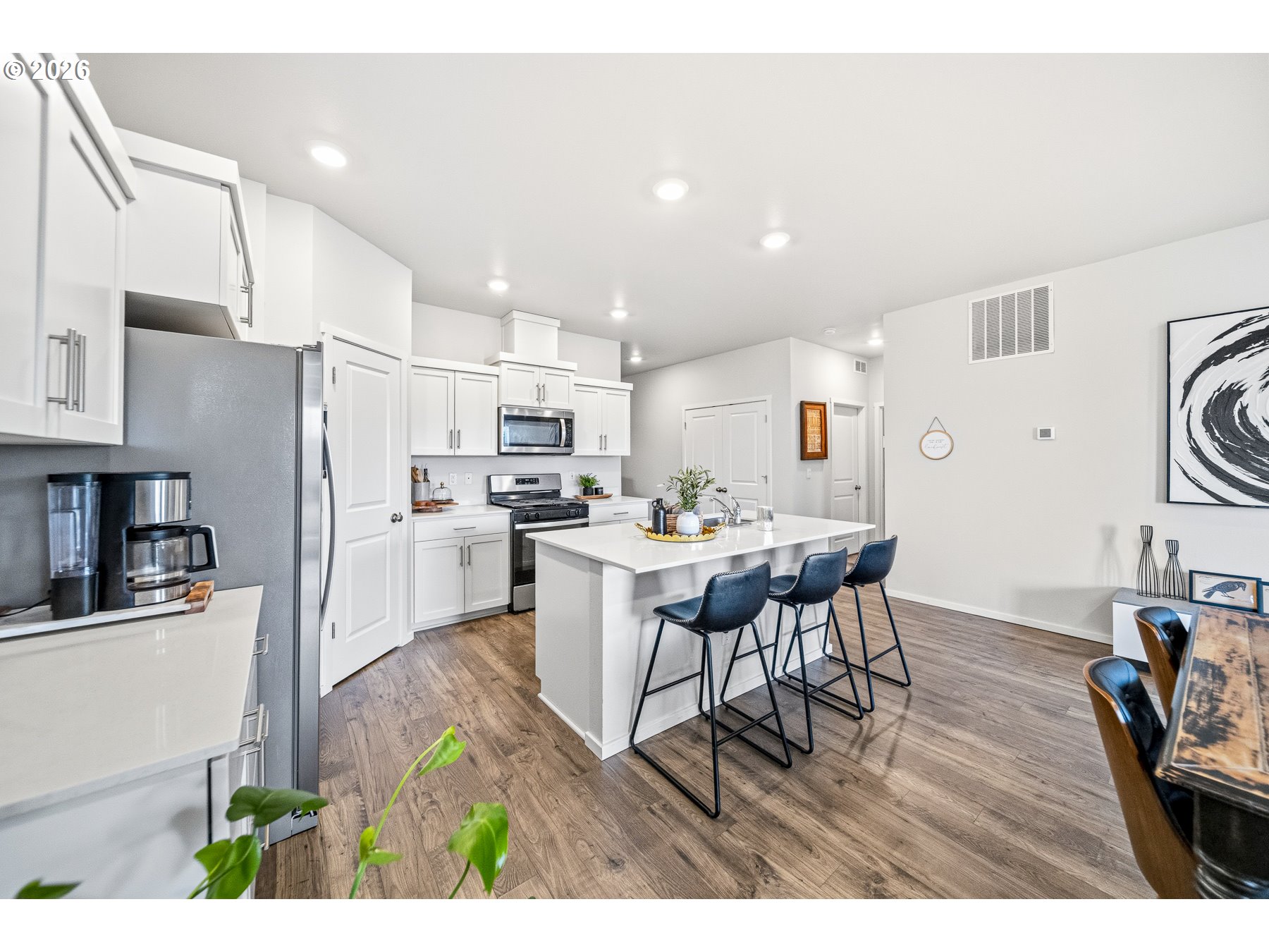 597 Northeast Union Loop Prineville, OR 97754 - Photo 6 of 22 a kitchen with stainless steel appliances kitchen island granite countertop a refrigerator a stove a sink dishwasher and white cabinets with wooden floor