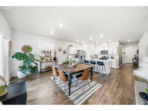 a living room with furniture and a dining table with wooden floor