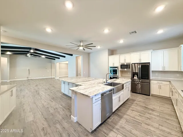 a large kitchen with kitchen island a sink counter top space a stove and cabinets