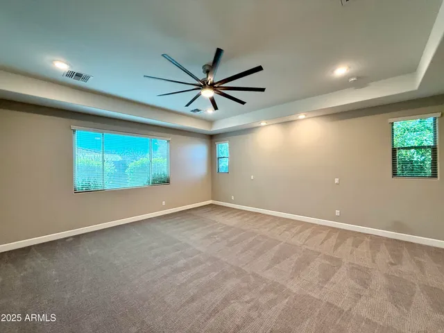 an empty room with windows and fan