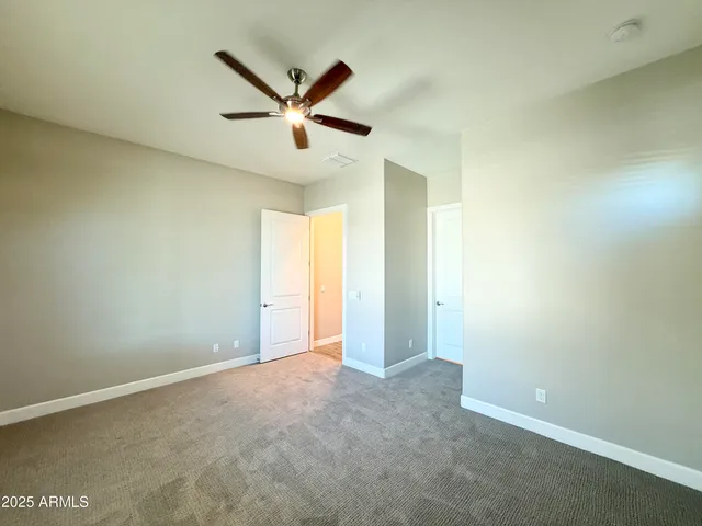 an empty room with ceiling fan and window