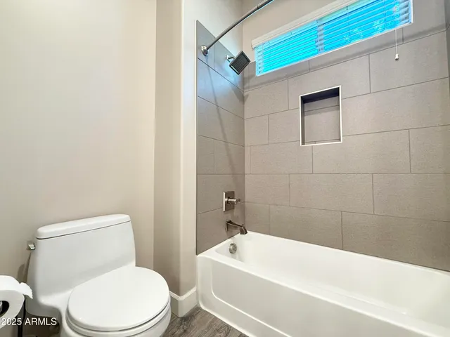 a white toilet sitting next to a bath tub