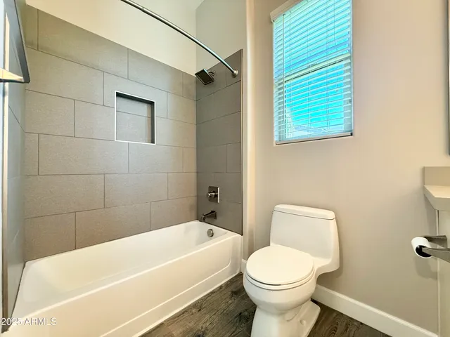 a white toilet sitting next to a white bath tub