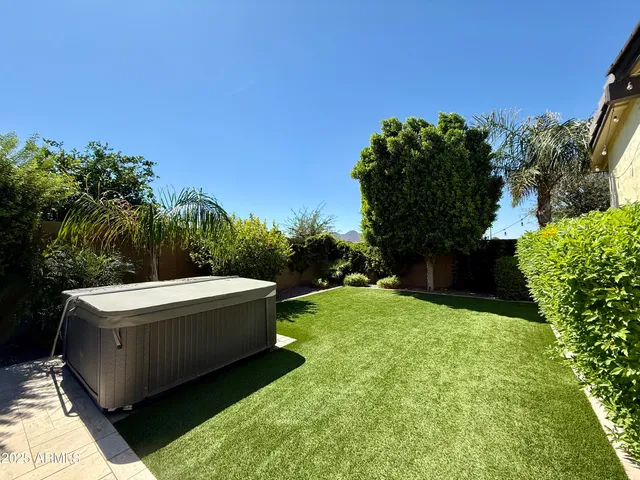 a backyard of a house with large trees and outdoor seating