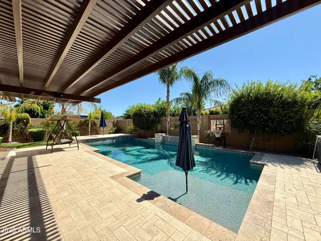 a patio with table and chairs and potted plants