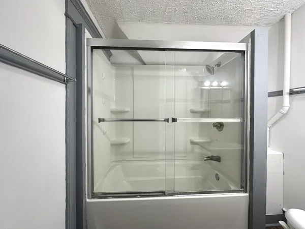 a bathroom with a glass shower door