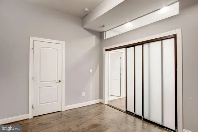 a view of a room with wooden floor and entryway