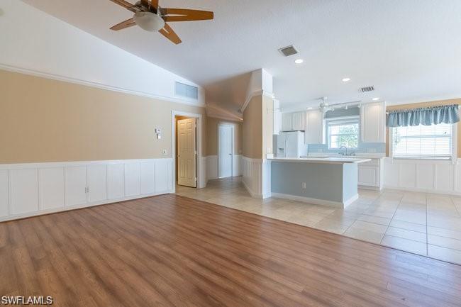 7640 Rozzini Lane Naples, FL 34114 - Photo 6 of 12 a view of a kitchen with a fridge wooden floor and a window