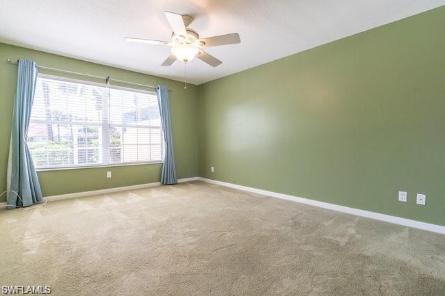 7640 Rozzini Lane Naples, FL 34114 - Photo 7 of 12 an empty room with windows and chandelier fan