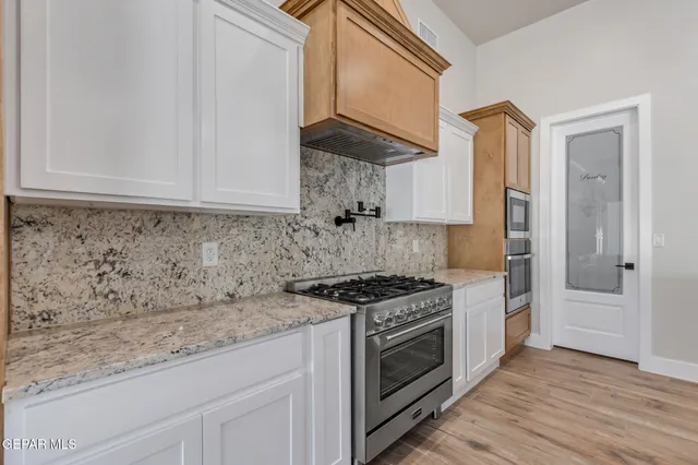a kitchen with granite countertop a sink and a stove