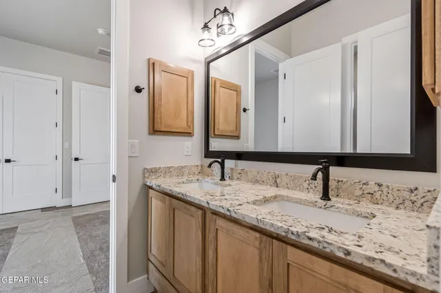 a bathroom with a granite countertop sink and a mirror