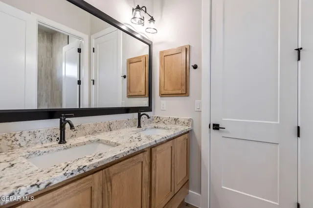 a bathroom with a granite countertop sink and a mirror