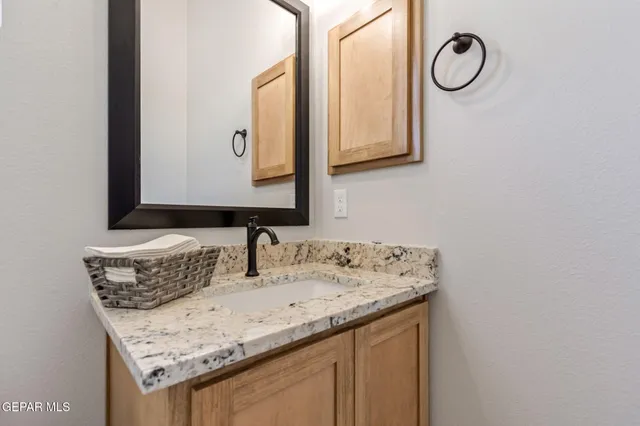 a bathroom with a granite countertop sink and a mirror