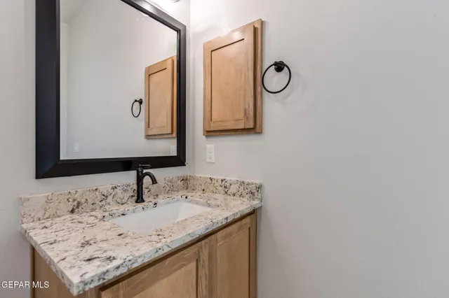 a bathroom with a granite countertop sink and a mirror