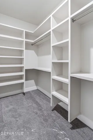 a view of walk in closet with empty racks