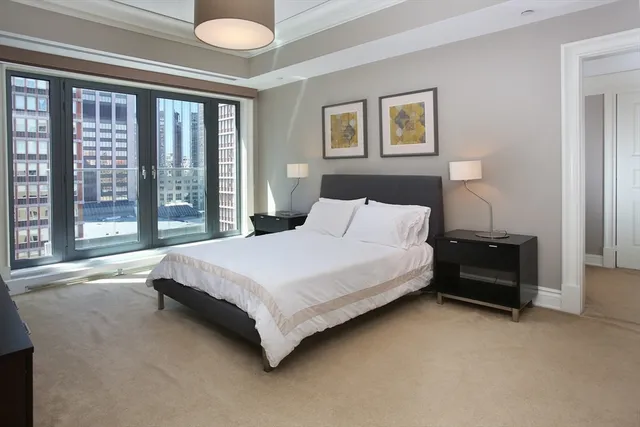 a bedroom with a bed and a large window