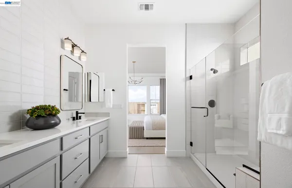 a bathroom with a double vanity sink and shower