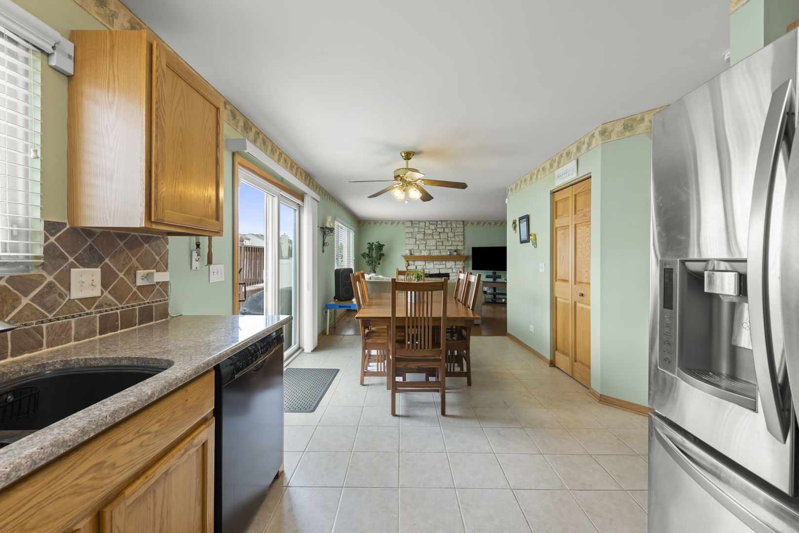 2217 Cedar Ridge Drive Plainfield, IL 60586 - Photo 8 of 26 a kitchen with stainless steel appliances kitchen island granite countertop dining table chair and a refrigerator