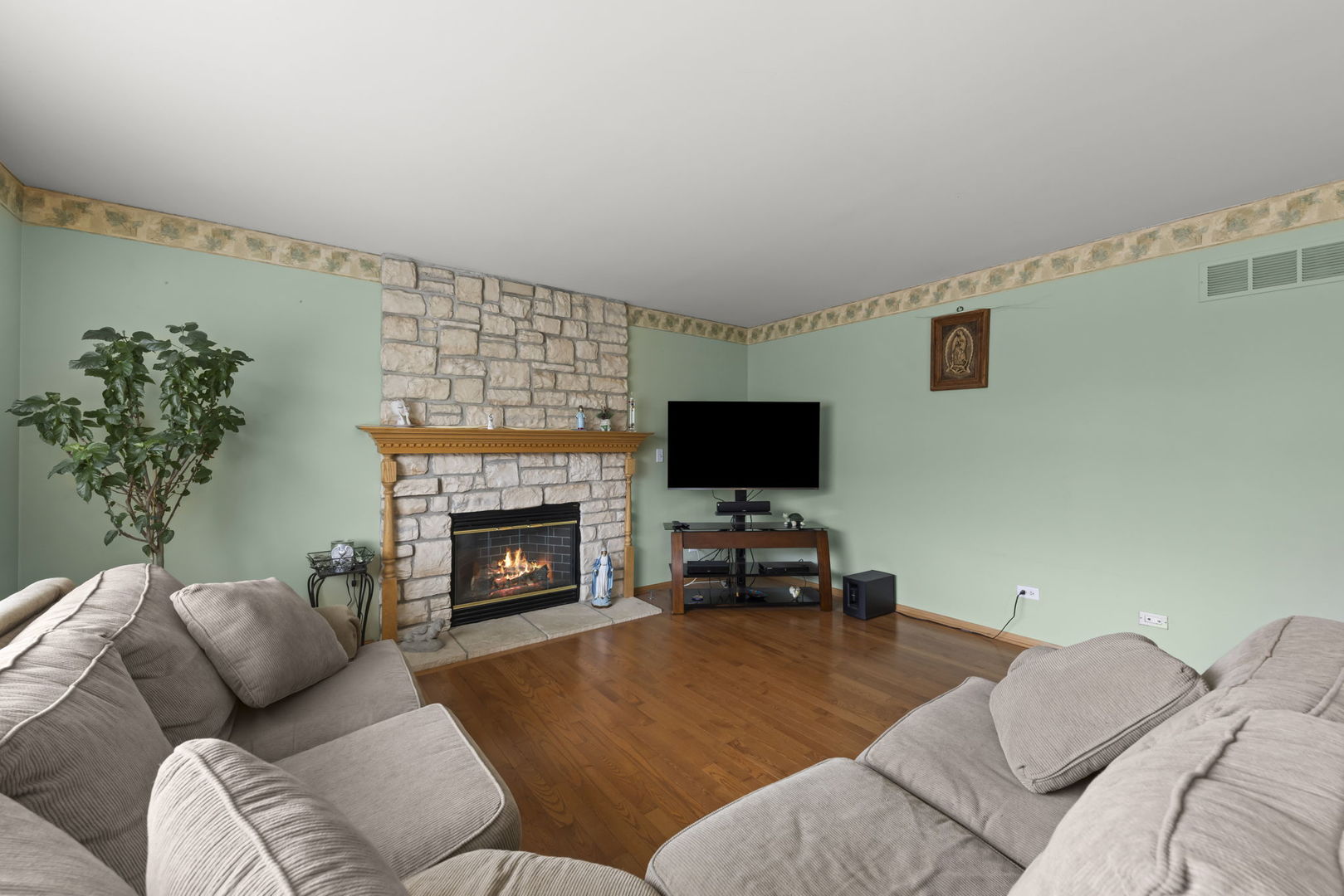 2217 Cedar Ridge Drive Plainfield, IL 60586 - Photo 10 of 26 a living room with furniture a fireplace and a flat screen tv