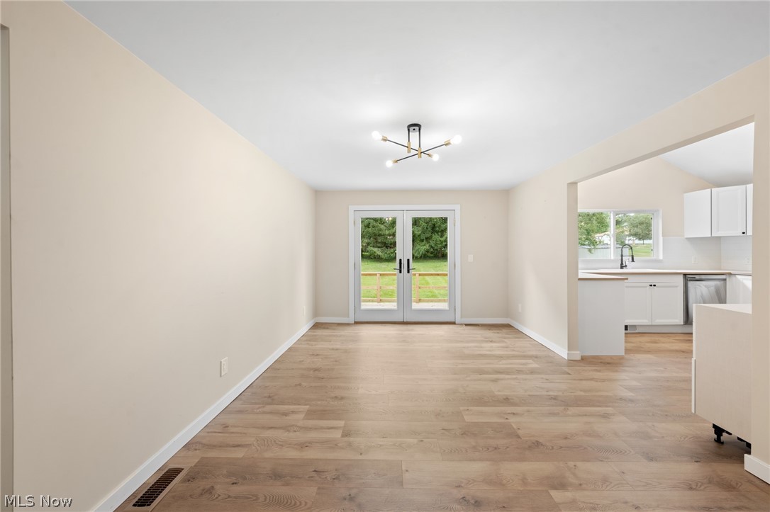 1617 Graham Road Stow, OH 44224 - Photo 26 of 49 Empty room featuring light hardwood / wood-style floors, an inviting chandelier, french doors, and plenty of natural light