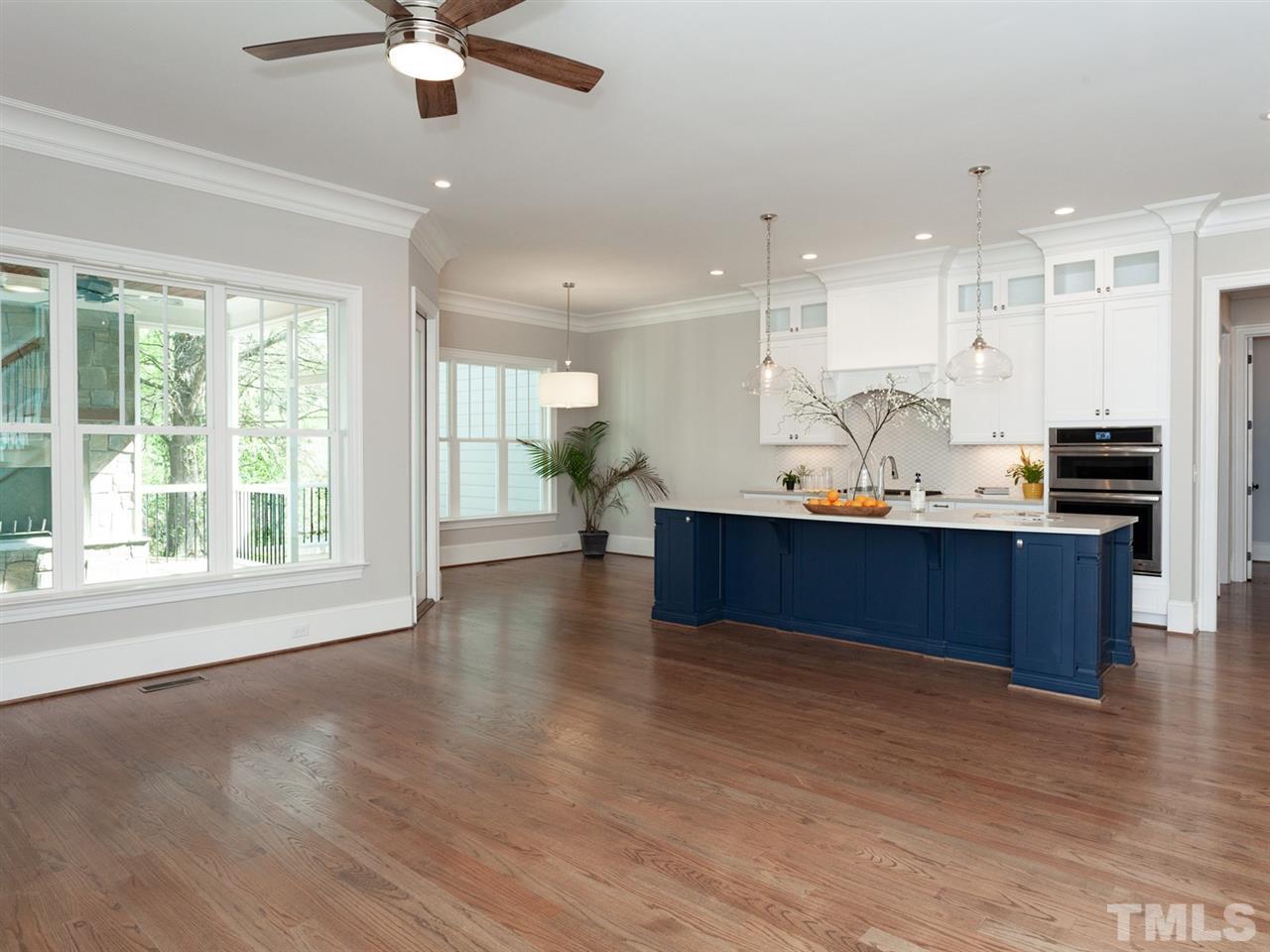 2804 Oberry Street Raleigh, NC 27607 - Photo 9 of 25 a kitchen with stainless steel appliances kitchen island granite countertop a sink dishwasher and a dining table with wooden floor