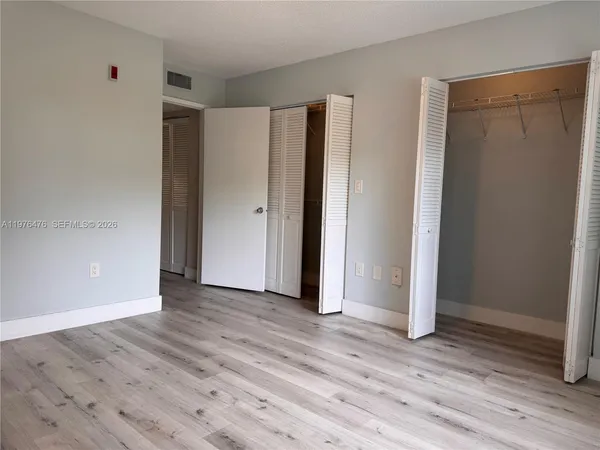 a view of an empty room with wooden floor