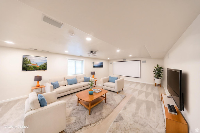 2169 Orchard Pines Loop East Bountiful, UT 84010 - Photo 23 of 32 Spacious entertainment area featuring recessed lighting, a large projection screen, and a wall-mounted flat-screen television