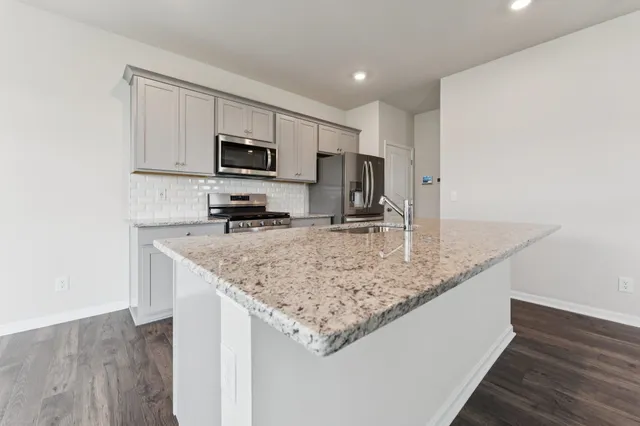 a kitchen with stainless steel appliances granite countertop a sink a microwave counter space and cabinets