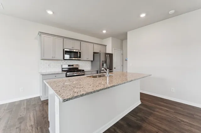 a kitchen with a sink a microwave a stove and refrigerator