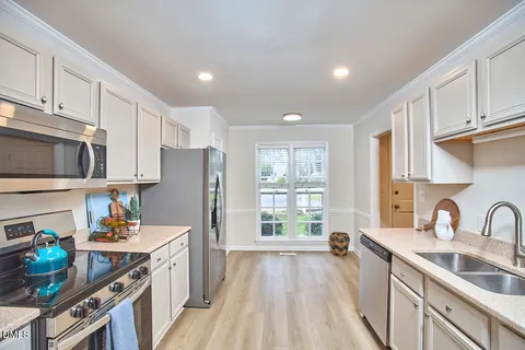a kitchen with sink a refrigerator and cabinets