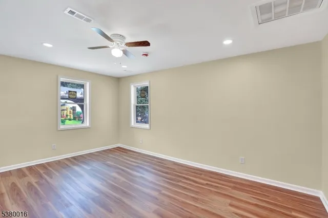 a view of an empty room with wooden floor