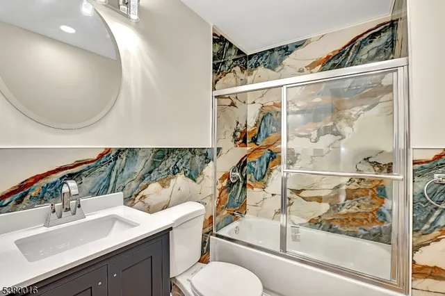 a bathroom with a sink mirror vanity and toilet